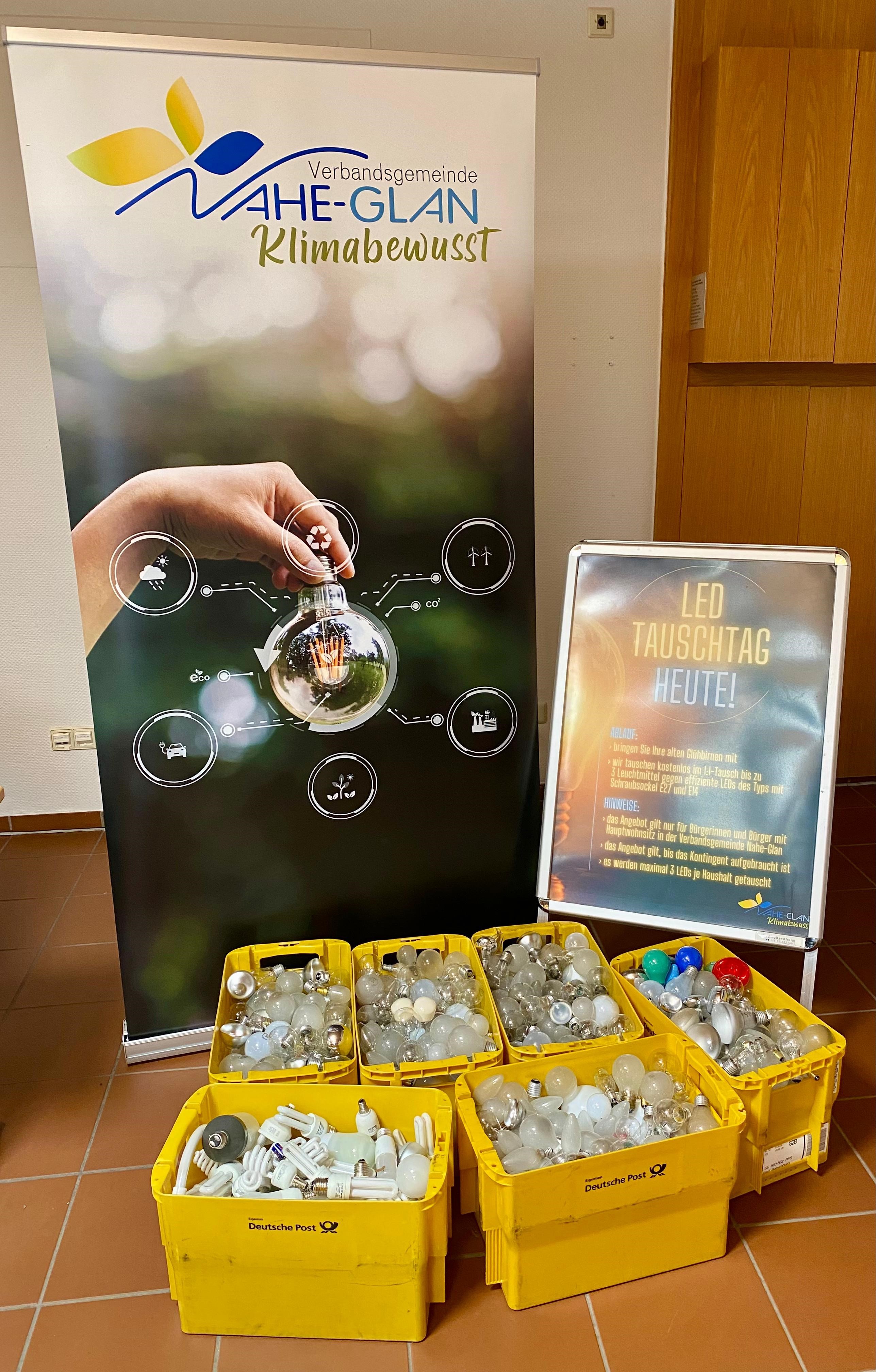 Kisten mit alten Glühbirnen vor Klimaschutzbanner