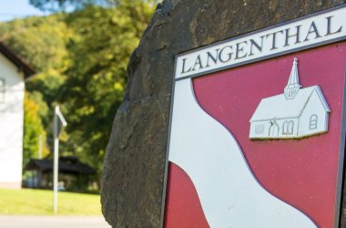 Foto des Wappens der Ortsgemeinde Langenthal auf einem Stein