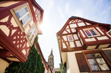 historische Fachwerkgebäude mit Kirchturm im Hintergrund