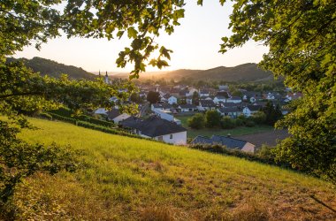 Ortsansicht umrahmt von grüner hügeliger Landschaft