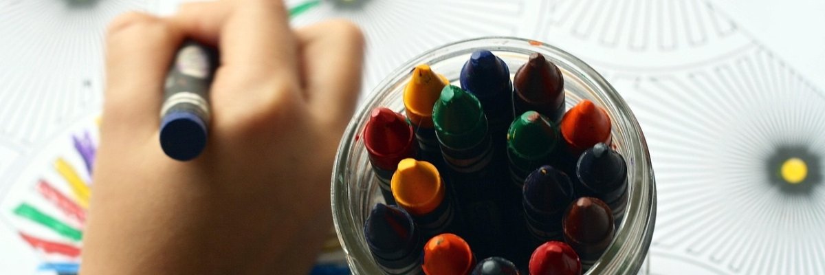 Symbolbild Kindergartenkinder. Neun Kinder im Kindergartenalter sitzen fröhlich in einer Reihe.