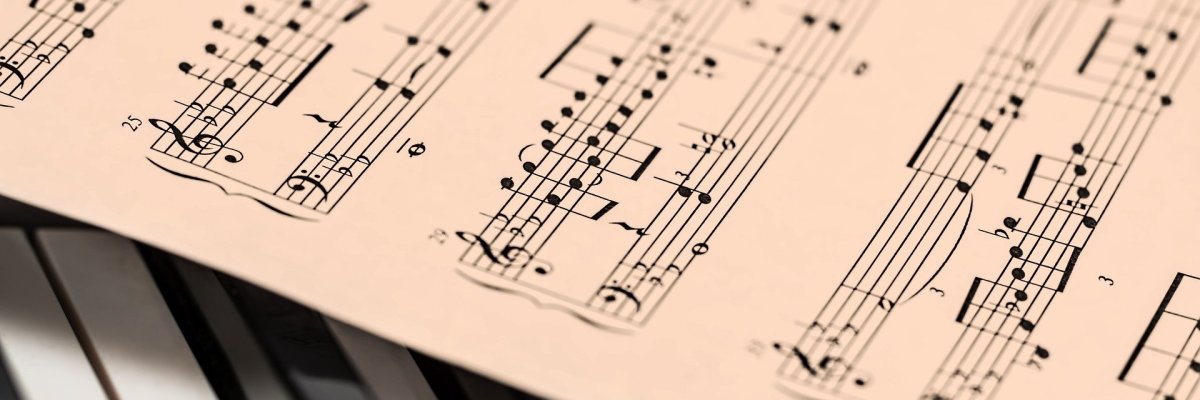 Symbolbild Nahaufnahme eines Notenblattes auf einer Klaviatur.