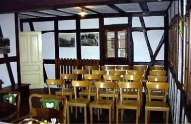 Innenaufnahme des dekorierten und bestuhlten, menschenleeren Trauzimmers Hasselbacher Rathaus im Freilichtmuseum Bad Sobernheim. Blick vom Saal zum Trautisch.