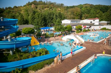 Luftaufnahme Freibad Bad Sobernheim zeigt einen Teil des Freibades mit drei Becken, zwei Rutschen und Badegästen.