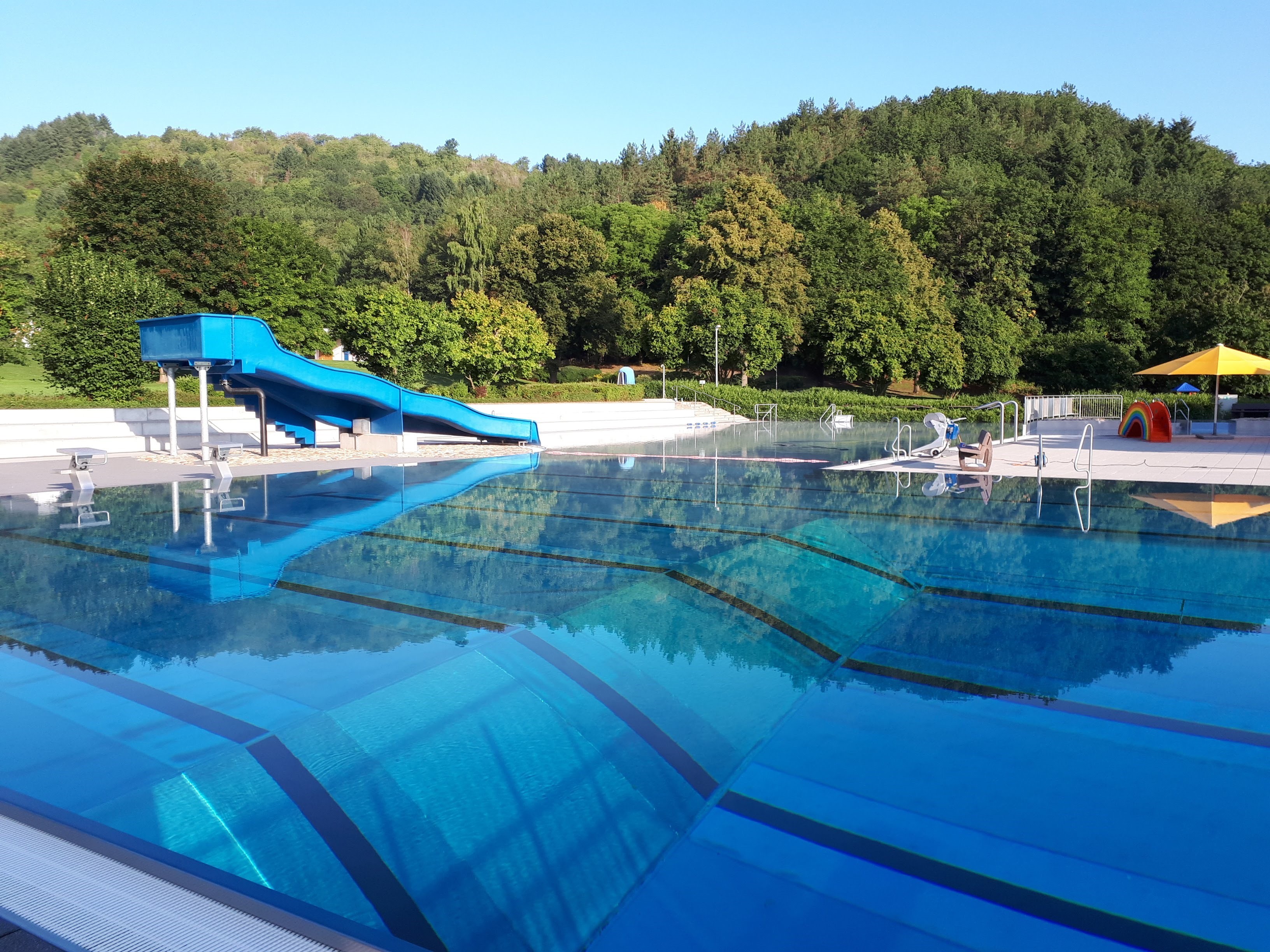 Aufnahme eines Schwimmbeckens mit Rutsche im Freibad Meisenheim ohne Badegäste.