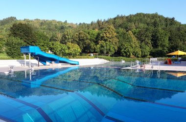 Aufnahme eines Schwimmbeckens mit Rutsche im Freibad Meisenheim ohne Badegäste.